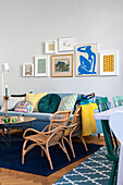 Living room with gallery wall, rattan armchairs and colourful decorative cushions