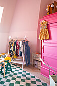 Children's room with clothes rack and wardrobe in pink