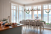 Festively laid dining table and Christmas decorations in a light-flooded room