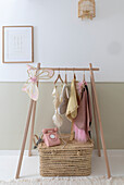 Wooden coat rack and pink telephone on woven basket