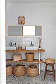 Washplace with mirror, rustic wooden shelf and baskets made of natural material