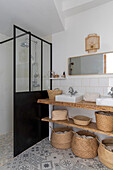 Bathroom with shower cubicle, storage baskets and patterned tiled floor