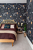 Bedroom with rattan headboard and patterned wallpaper with nature motifs