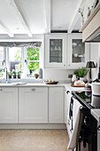 Bright country-style kitchen with fitted cupboards