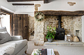 Rustic living room with exposed wooden beams and natural stone wall