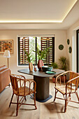 Dining table with wicker chairs and modern decoration