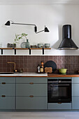 Modern kitchen with light blue cupboards and brown tiles