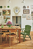 Essbereich im Vintage-Stil mit Holztisch und grünem Rattanstuhl