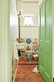 Small guest WC with colourful tiles, terracotta tiles and green door