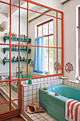 Badezimmer mit grüner Badewanne, maritimer Dekoration und Wandregalen
