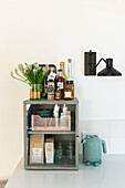 Metal shelf with spirits, glasses, kettle and wall lamp