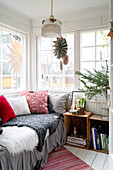 Hell gestaltete Leseecke mit Tagesbett und winterlicher Dekoration