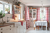 Landhausküche mit karierten Vorhängen und rustikalen Möbeln