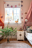 Kinderzimmer mit Weihnachtsdeko, Tannenbaum und Menora im Fenster