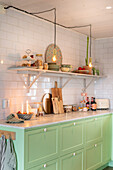Mint green kitchen unit with shelf and candlelight