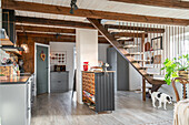 Küche im Landhausstil mit Holzbalken und offener Holztreppe