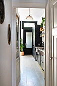 View of the kitchen with black cupboards and whitewash floorboards