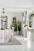 Dining room decorated for Christmas with white interior and Christmas tree