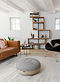 Bright living room with leather couch and shelves