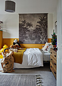 Children's room with yellow accents, Santa's sack in front of the bed