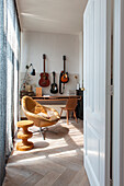 Blick ins Zimmer mit Vintage Ledersessel, Schreibtisch und Gitarrensammlung