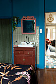 Vintage wooden vanity unit in bedroom with blue wall