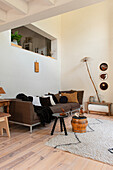 Wohnzimmer mit braunem Sofa und dekorativer Wandgestaltung