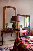 Antique dressing table with Buddha lamp and gold-framed mirror in the bedroom