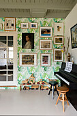 Wand mit tropischem Tapetenmuster und vielfältiger Bildergalerie im Musikzimmer