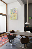 Essbereich mit Holztisch, Stühlen und Kunstwerk an der Wand