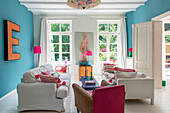 Bright living room with strong blue tones on the walls and colorful accents