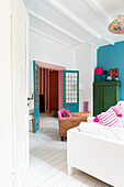 Helles Wohnzimmer mit farbenfroher Einrichtung und weißen Dielenböden