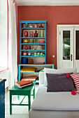 Buntes Wohnzimmer mit blauem Regal und farbigen Dekorationselementen