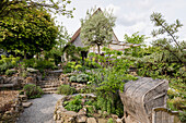 Terrassengarten mit Trockenmauern und vielfältiger Bepflanzung vor Landhaus