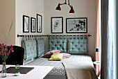 Upholstered bed with decorative cushions and murals in the bedroom