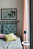 Upholstered headboard and graphic bed linen design in a modern bedroom