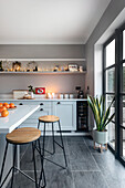 Modern kitchen with kitchen counter, stools and shelves