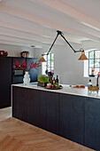 Modern kitchen unit with dark cabinets and stylish lighting
