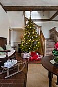 Decorated Christmas tree with presents in rustic entrance area