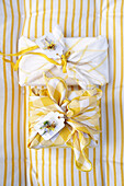 Gifts in yellow and white chequered cloth with decorative tags