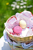 Easter basket with colorful eggs in a meadow in spring