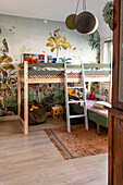 Loft bed and toys in children's room with jungle wallpaper