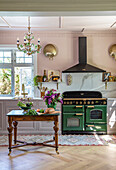 Küche im Vintage-Stil mit grünem Herd und Holztisch