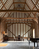 Piano in open living room of a renovated barn with wooden beams