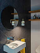 Gäste-Toilette mit kleinen, schwarzen, wabenförmigen Wandlfiesen