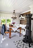Country-style dining area with tiled stove and wooden table