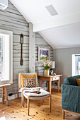 Holzvertäfeltes Zimmer mit Leseecke und dekorativer Wandgestaltung