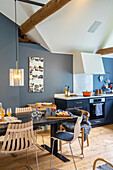 Kitchen corner with blue walls and wooden furniture under a sloping ceiling