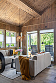 Living room with pitched roof and wood panelling, modern furnishings