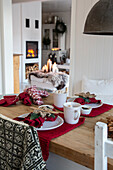 Set dining table with crocheted accessories and open fire in the background